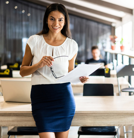 professional smiling woman holding glasses and paper at the office