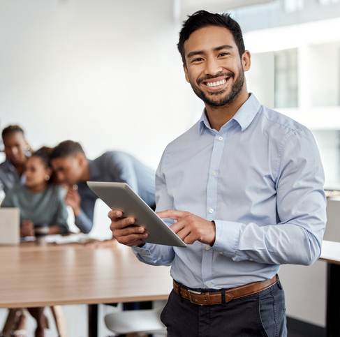 smiling professional male in office holding iPad